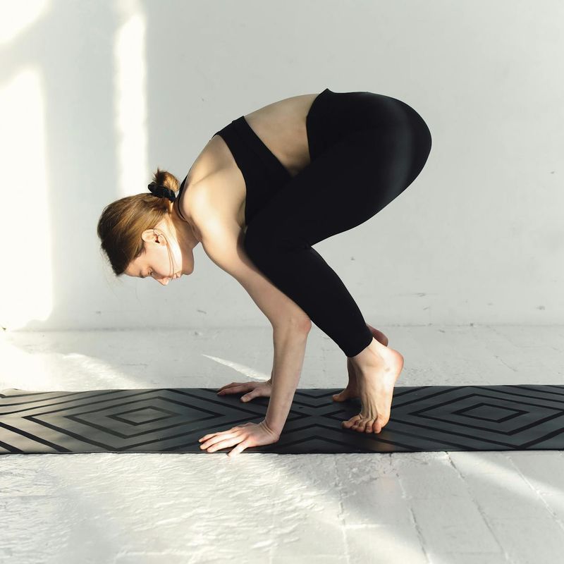 Woman holding a challenging yoga balance pose with confidence.